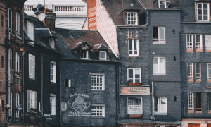 Historic slate gray buildings with rustic charm and vintage French signage