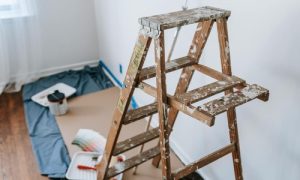 Wooden ladder and painting tools set up in a room being prepared for renovation or repainting.