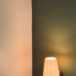 Dark green wall section next to a light wall, lit by a wall sconce.